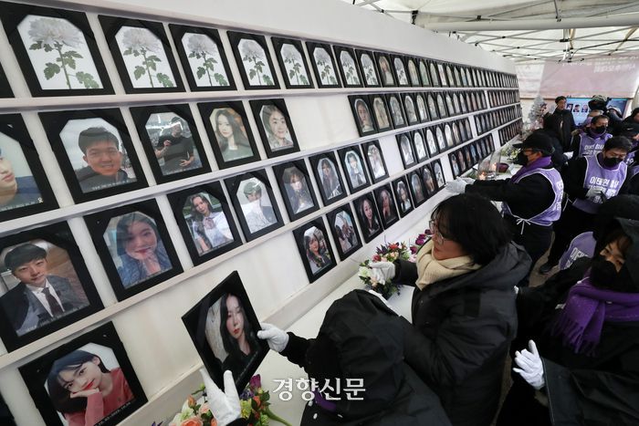 10·29 이태원 참사 유가족협의회와 시민대책회의 관계자들이 17일 서울광장 분향소에서 특별법 공포와 독립적 조사기구 설립을 촉구하며 용산 대통령실 방향으로 행진하기에 앞서 희생자들의 영정을 챙기고 있다.