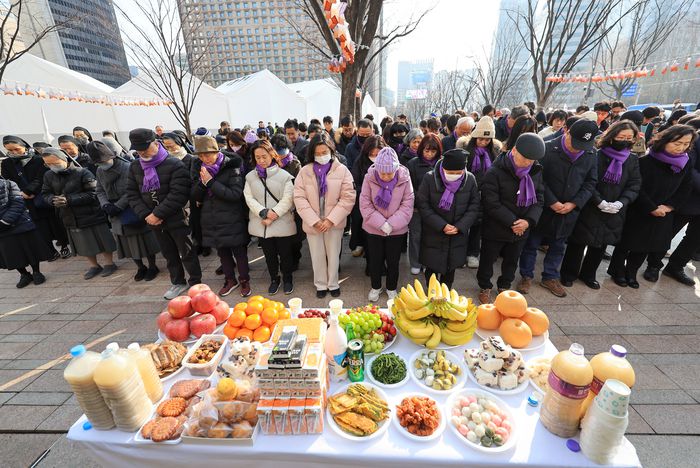 설날인 10일 서울광장에 마련된 10·29 이태원 참사 희생자 합동분향소에서 유가족들이 떡국 나눔을 하기 전 묵념하고 있다. 연합뉴스