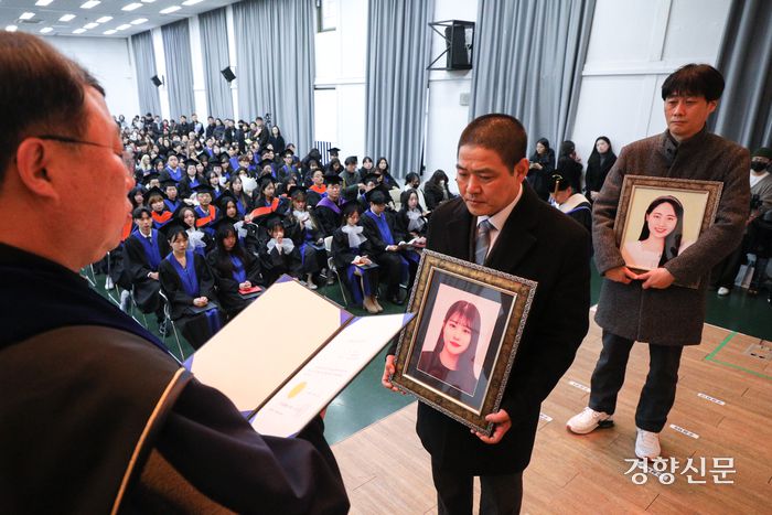 이태원 참사 희생자 고 유연주씨 아버지 유형우씨와 고 진세은씨 아버지 진정호씨가 15일 서울 구로구 성공회대학교에서 열린 학위수여식에서 고인들을 대신해 명예학사학위를 받고 있다. ‘코로나 학번’이었던 진씨와 유씨는 대학 기숙사 룸메이트로 참사 당일 함께 이태원에 갔다가 돌아오지 못했다. 성동훈 기자