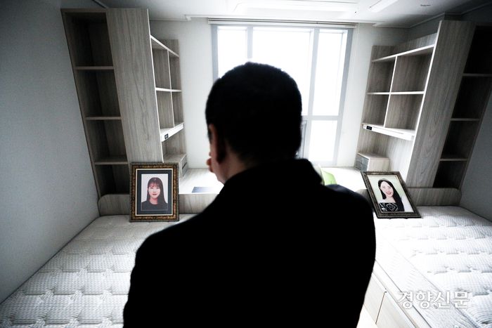 이태원 참사 희생자 고 유연주씨의 아버지 유형우씨가 15일 서울 구로구 성공회대학교에서 열린 학위수여식이 끝난 뒤 기숙사를 찾아 딸이 사용했던 침대(왼쪽)를 보고 슬퍼하고 있다. 오른쪽 침대에는 참사 당일 함께 희생된 고 유씨의 룸메이트 고 진세은씨 영정이 놓여 있다. 성동훈 기자