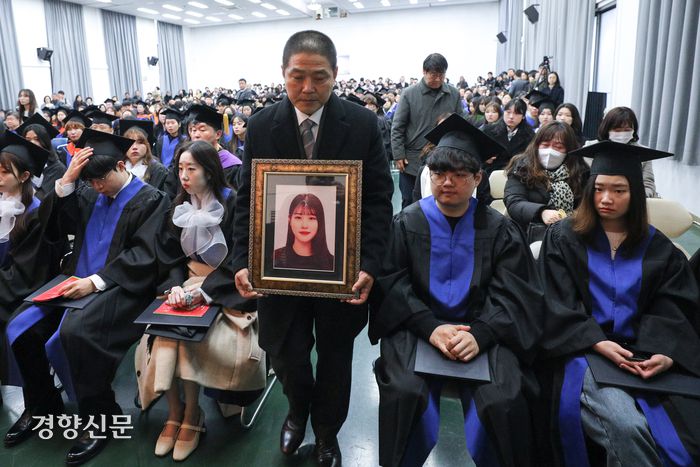 이태원 참사 희생자 고 유연주씨의 아버지 유형우씨가 15일 딸의 모교인 서울 구로구 성공회대학교에서 열린 학위수여식에서 명예학사학위를 받기 위해 연단으로 향하고 있다.  성동훈 기자