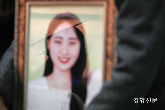 15일 서울 구로구 성공회대학교에서 열린 학위수여식에서 이태원 참사 희생자인 고 진세은씨의 영정에 다른 졸업생들이 학사모를 쓴 모습이 비치고 있다.  성동훈 기자