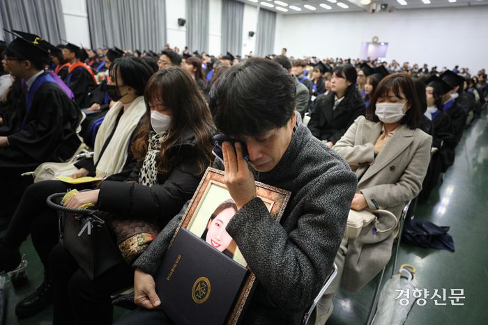 이태원 참사 희생자 고 진세은씨의 아버지 진정호씨와 어머니 설모씨가 15일 딸의 모교인 서울 구로구 성공회대학교에서 열린 학위수여식에서 받은 명예학사학위증을 들고 눈물을 흘리고 있다. 성동훈 기자