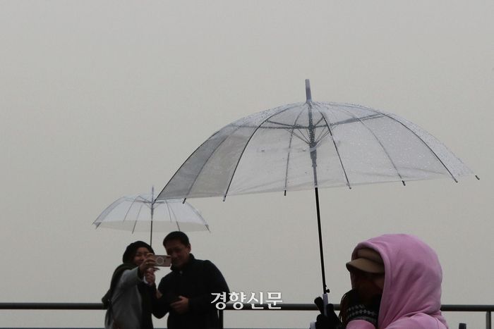 내몽골고원으로부터 황사가 유입되며 전국 대부분 지역이 미세먼지 농도 나쁨 수준을 보인 29일 시민들이 서울 용산구 남산타워에서 황사비를 피해 우산을 쓰고 있다. 2024.03.29 한수빈 기자