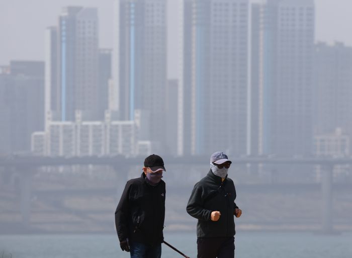 올봄 첫 황사 유입으로 미세먼지 농도가 나쁨 수준으로 올라갔던 지난달 17일 서울 잠실한강공원을 찾은 시민들이 마스크를 쓰고 산책하고 있다. 연합뉴스.