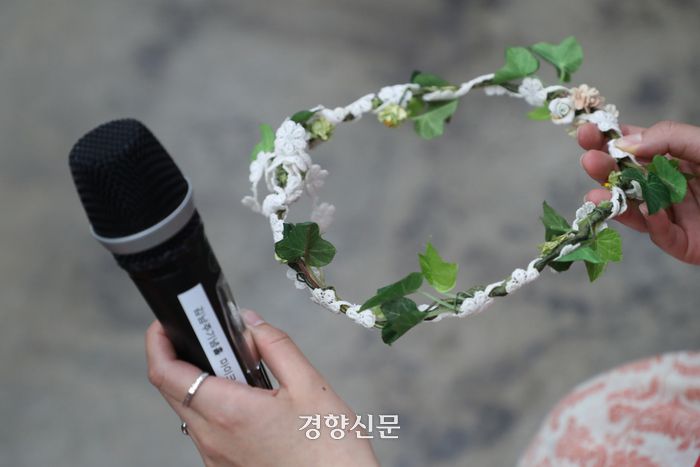 5·18 민주화운동 당시 계엄군 등에 의해 성폭력 피해를 입은 피해자가 지난달 28일 광주광역시 전남대학교 김남주홀에서 ‘5·18 민주화운동진상규명조사위원회’ 주최로 열린 간담회에서 마이크와 머리띠를 들고 있다. 정효진 기자