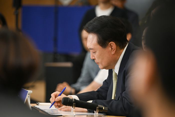윤석열 대통령이 14일 서울 중구 서울고용복지플러스센터에서 열린 스물다섯번째 ‘국민과 함께하는 민생토론회’에서 토론자들의 발언을 메모하고 있다. 이날 토론회는 ‘고맙습니다, 함께 보듬는 노동현장’을 주제로 진행됐다. 대통령실 제공