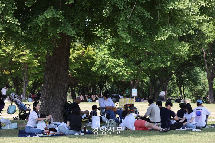 휴일을 맞아 나들이 나온 시민들이 서울숲에서 그늘에 돗자리를 펴고 각자 시간을 보내고 있다.