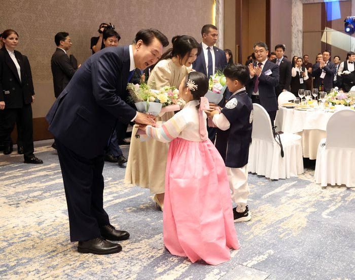 윤석열 대통령이 13일 오후(현지시간) 우즈베키스탄 타슈켄트 힐튼 호텔에서 열린 동포 만찬간담회에 참석하며 화동들과 인사하고 있다.  김창길 기자