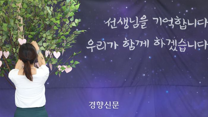 서이초 교사 1주기를 사흘 앞둔 지난 15일 서울 종로구 서울시교육청 옆에 마련된 추모공간을 찾은 추모객이 추모 메시지를 걸고 있다. 정효진 기자