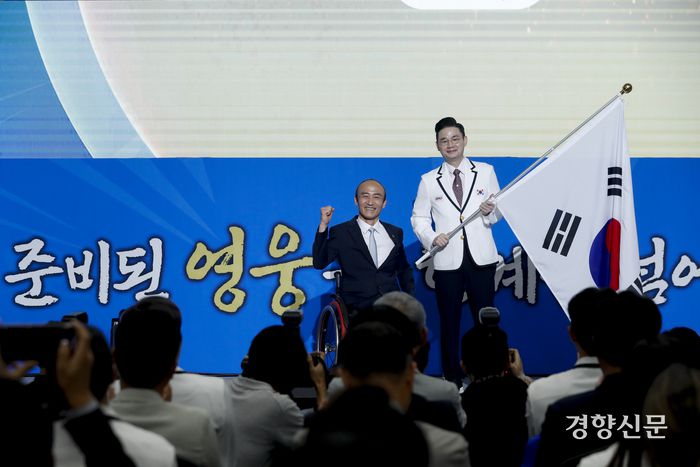 2024 파리 패럴림픽 결단식이 열린 12일 서울 송파구 올림픽파크텔에서 대한장애인체육회 정진완 회장(왼쪽)과 배동현 선수단장이 단기를 들고 기념촬영을 하고 있다.  문재원 기자