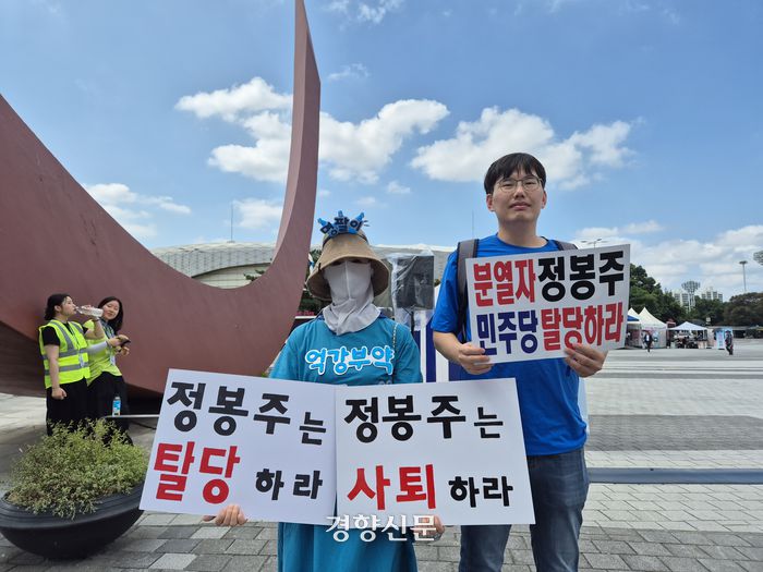 18일 더불어민주당 8.18 정기전국전당대회가 열린 서울 올림픽공원 한얼광장에 정봉주 최고위원 후보의 사퇴를 요구하는 민주당 권리당원들이 손팻말을 들고 서있다. 이유진 기