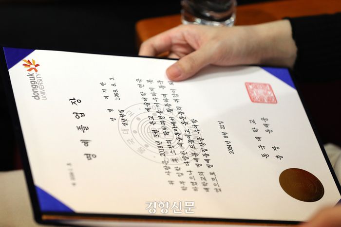 이태원 참사 희생자 고 이지한씨의 누나 이가영씨가 22일 서울 중구 동국대학교에서 열린 가을 학위수여식에서 이씨의 명예 졸업장을 살펴보고 있다. 조태형 기자