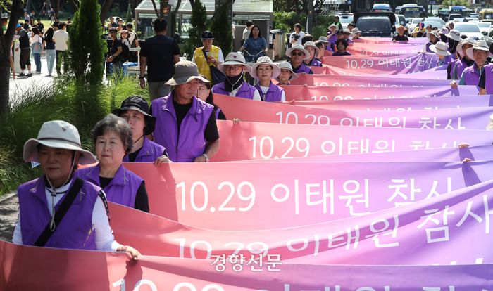 이태원 참사 유가족협의회 및 시민단체 회원들이 30일 서울 중구 서울 도서관 앞에서 10.29 이태원 참사 2주기 추모의 달 선포 기자회견을 마치고 서울 서부지방법원을 향해 행진하고 있다. 성동훈 기자