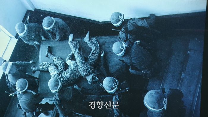 1980년 5월27일 옛 전남도청 경찰국에서 계엄군들이 진압작전 도중 사살한 청소년 2명의 시신을 옮기고 있다. 교련복을 입은 이들은 당시 고등학교 1학년 이었던 문재학과 안종필 열사로 확인됐다. 문재학은 한강의 소설 <소년의 온다>의 실제 주인공이다. 경향신문 자료.