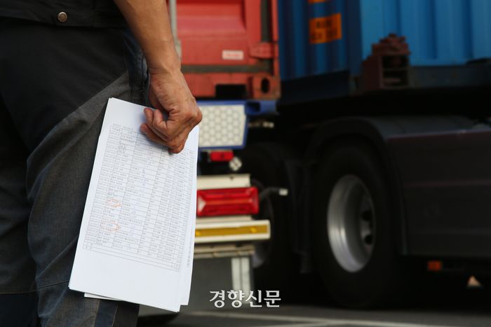 지난해 8월 경기 의왕 내륙컨테이너기지(ICD)에서 한 화물기사가 자신의 화물차 컨테이너 옆에서 거래명세서를 들고 있다. 조해람 기자
