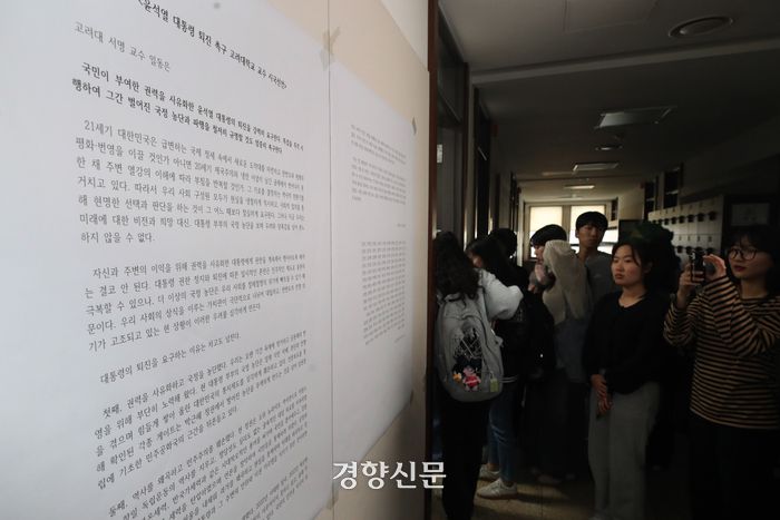 서울 성북구 고려대학교 안암캠퍼스에 14일 게시된 교수 시국선언문을 학생들이 읽고 있다. 정효진 기자
