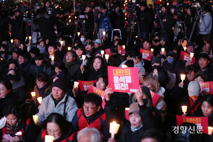 4일 오후 서울 동화면세점 앞에서 전국민주노동조합총연맹 주최로 열린 ‘내란죄 윤석열 퇴진! 시민촛불’에서 참가자들이 촛불을 들고 있다. 정지윤 선임기자