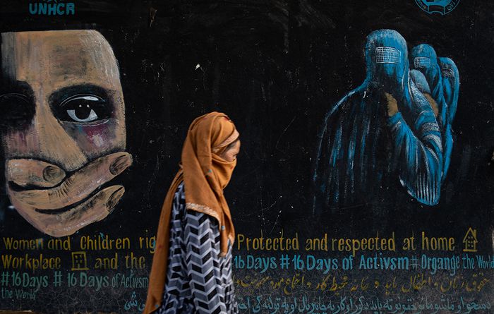 2022년 8월 아프가니스탄 바미안에서 한 여성이 여성과 아동 권리를 촉구하는 벽화 앞을 지나가고 있다. 게티이미지