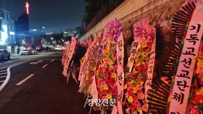 11일 밤 서울 용산구 대통령실 인근 도로에 윤석열 대통령의 탄핵을 반대하는 지지자들이 보낸 화환이 늘어서 있다. 강한들 기자