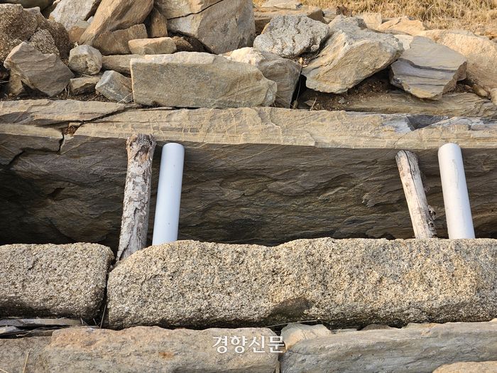 충북 청주시 상당구 월오동 ‘고인돌 역사테마공원’의 고인돌 돌과 돌 사이에 PVC재질의 파이프와 나무가 끼워져 있다. 이삭 기자.