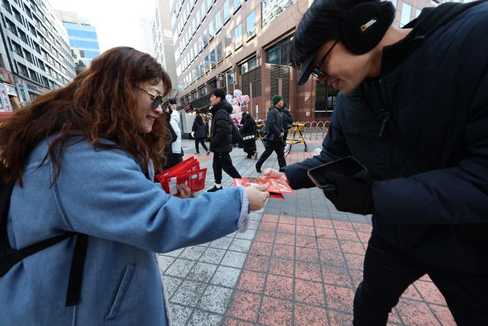 온기 나눠요 윤석열 대통령에 대한 두 번째 탄핵소추안 국회 표결일인 14일 서울 여의도 국회 앞 거리에서 한 시민이 무료로 핫팩을 나눠주고 있다.  연합뉴스