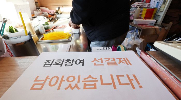 윤석열 대통령에 대한 탄핵소추안 재표결이 이뤄진 지난 14일 서울 영등포구 여의도 국회 앞의 한 김밥집에 선결제 관련 안내문이 놓여 있다. 연합뉴스