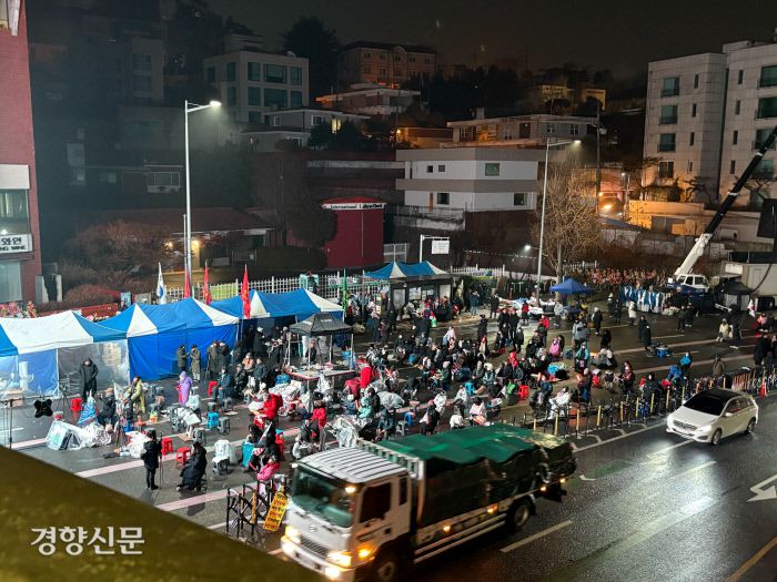 찬 바람에 그대로… 윤석열 대통령 지지 집회에 참여한 참가자들이 14일 오전 7시쯤 서울 용산구 한남동 대통령 관저 앞 농성장에서 스크린을 보며 대기하고 있다. 배시은 기자