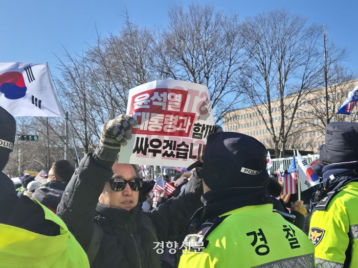 한 남성이 15일 정부 과천청사 인근을 통제 중인 경찰 앞에서 ‘윤석열 대통령과 함께 싸우겠습니다’라고 적힌 손팻말을 들고 서 있다. 이예슬 기자