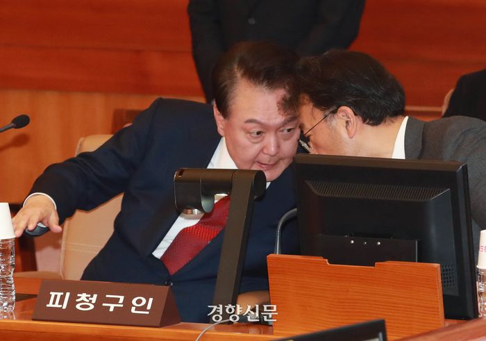 내란 우두머리 혐의로 구속된 윤석열 대통령이 21일 서울 종로구 헌법재판소 대심판정에서 열린 탄핵심판에 출석해 변호인과 대화하고 있다. 윤 대통령은 이날 12·3비상계엄 사태 이후 49일만에 공식석상에 모습을 드러냈다. 사진공동취재단