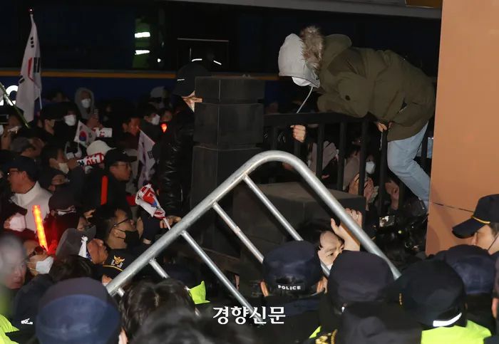 지난 18일 오후 서울 마포구 서울서부지법에서 ‘내란우두머리’ 혐의 등으로 체포된 윤석열 대통령의 구속 전 피의자 심문(영장실질심사)이 진행되고 있는 가운데, 윤석열 지지자들이 법원 담장을 넘어왔다가 다시 밖으로 나가고 있다. 한수빈 기자