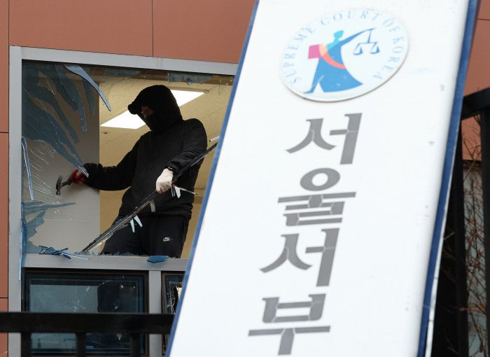 지난 1월19일 윤석열 대통령 구속 소식을 들은 일부 윤 대통령 지지자들이 불법폭력사태를 일으킨 서울 마포구 서울서부지방법원에서 한 작업자가 복구 작업을 하고 있다. 연합뉴스