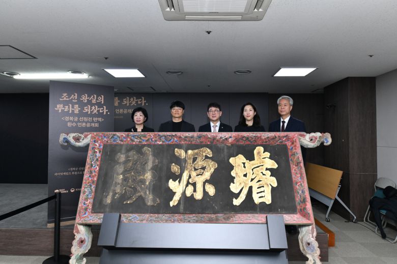 최응천 국가유산청장(왼쪽에서 세번째), 조혁진 라이엇게임즈 한국대표(두번째) 등이 27일 서울 종로구 국립고궁박물관에서 공개된 경복궁 선원전 편액 뒤에서 기념촬영하고 있다. 국가유산청 제공