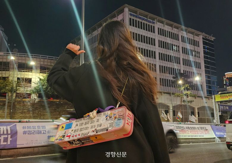 지난 3일 서울 중구 세종호텔 고공농성장 앞으로 해나(활동명·20)가 서 있다. 해나의 등 뒤에 분홍색 멜로디언이 메달려 있다. 우혜림 기자