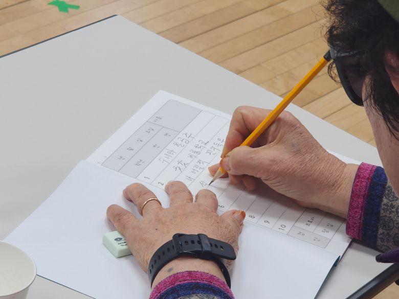 18일 열린 ‘수니와칠공주’ 공개 오디션에 참가한 한 할머니가 받아쓰기 시험을 보고 있다.