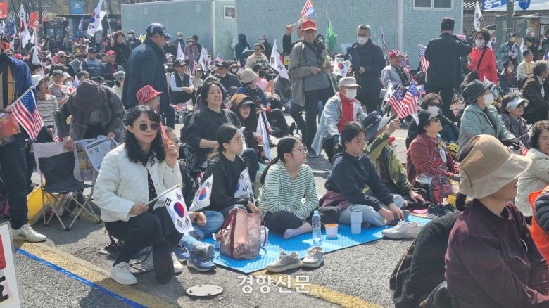 차예희씨(46)와 가족들이 22일 서울 종로구에서 열린 윤석열 대통령 탄핵 반대 집회에 참여하기 위해 돗자리를 펴고 앉아있다. 서현희 기자