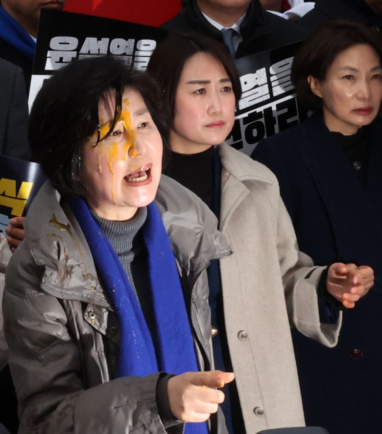 백혜련 더불어민주당 의원이 20일 서울 종로구 헌법재판소 앞에서 열린 윤석열 대통령 신속 파면 촉구 기자회견에서 한 보수단체 회원이 던진 계란으로 얼굴을 맞은 뒤 항의하고 있다. 연합뉴스