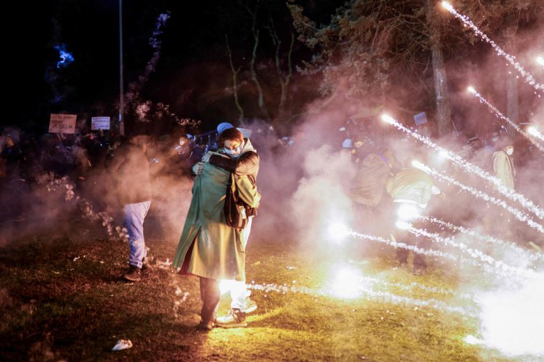 22일(현지시간) 튀르키예 이스탄불에서 열린 시위에서 경찰이 최루탄을 발사하자 근처에 있던 커플이 부둥켜안고 있다. AFP연합뉴스