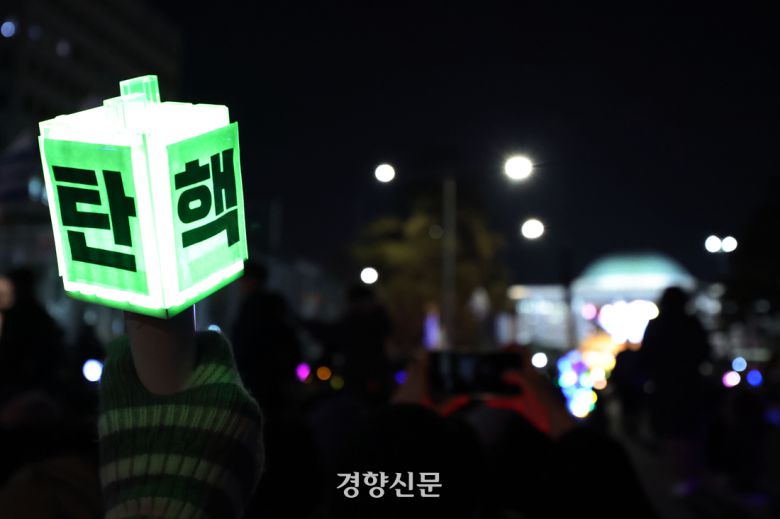 지난해 12월 13일 서울 여의도 국회 앞에서 열린 범국민촛불대행진에 참가한 시민이 응원봉을 들고 대통령(윤석열) 탄핵소추안 가결을 촉구하고 있다. 한수빈 기자