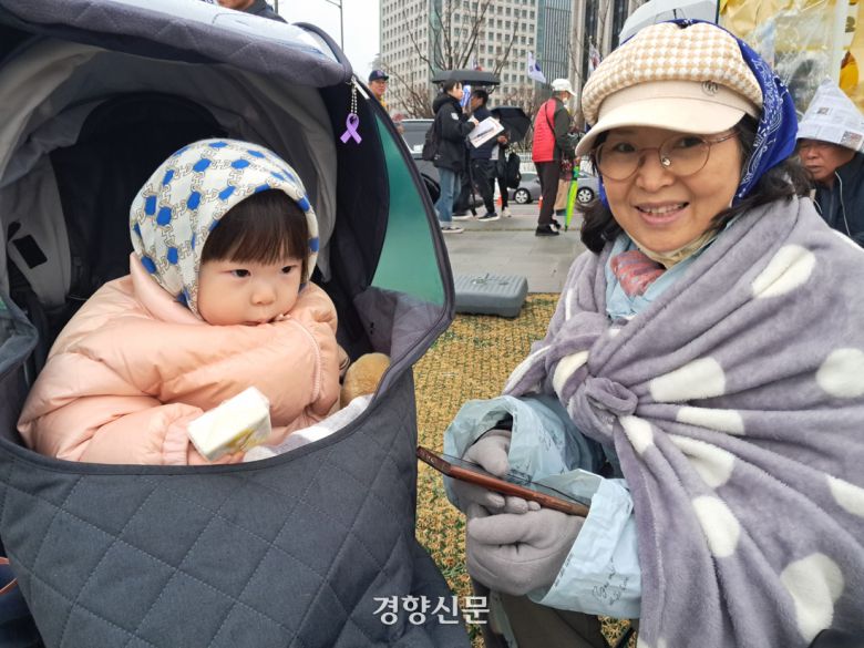 김정이씨(56·오른쪽)와 손녀가 5일 비상행동 등이 주최한 ‘18차 범시민대행진’에 참여하고 있다. 박정연 기자