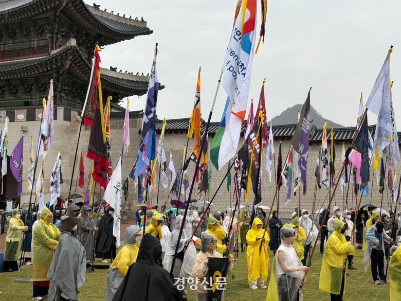 12일 오후 서울 종로구 경복궁 인근에서 열린 ‘세월호참사 11주기 기억·약속 시민대회’에 노란색 리본을 묶은 깃발을 든 시민들이 참여하고 있다.  배시은 기자