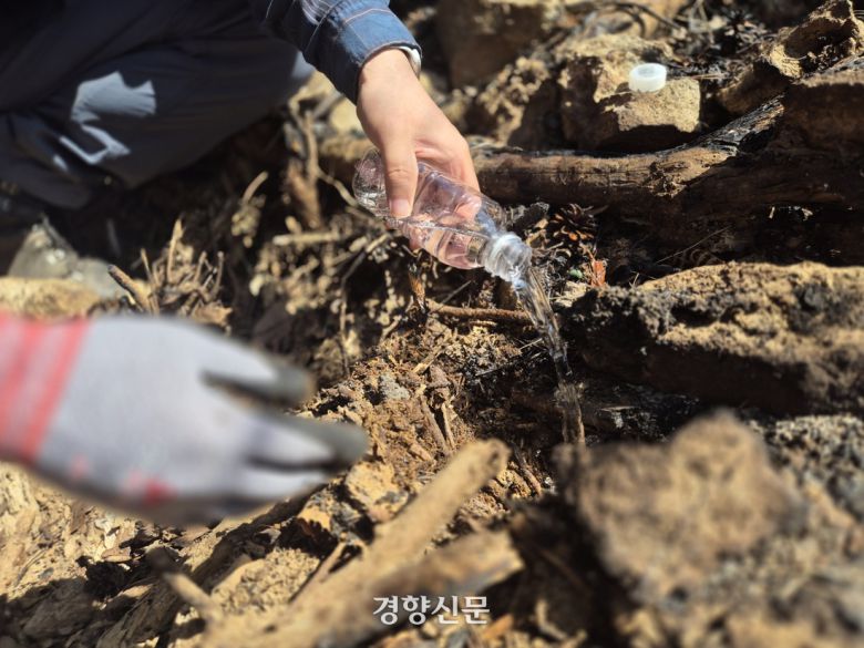 양대성 한국치산기술협회 산사태연구실 실장이 7일 경남 산청군 시천면 중태 마을 뒷산 흙에 물을 뿌려보고 있다. 물은 땅으로 스며들지 않고 경사로를 따라 줄줄 흘러 내려갔다. 반기웅 기자