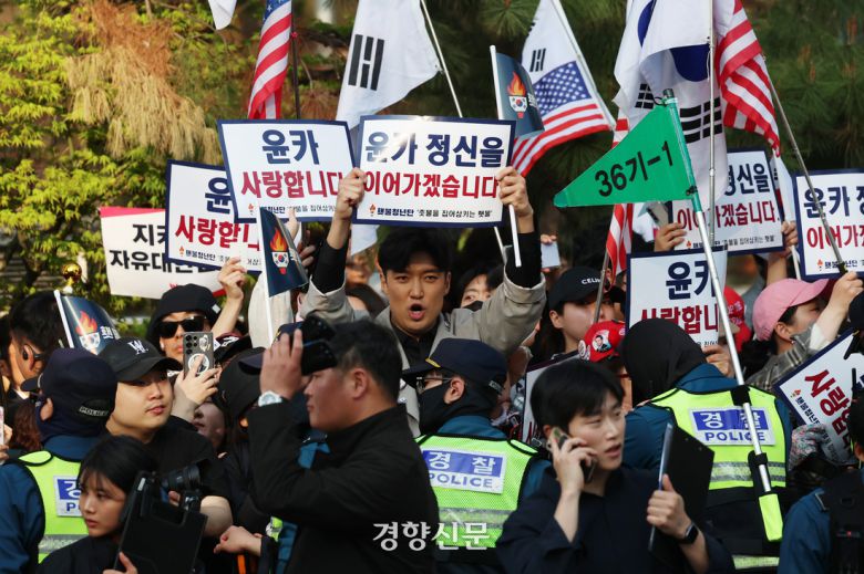 지난 11일 서울 한남동 대통령 관저에서 퇴거한 윤석열 전 대통령이 서울 서초구 자택에 도착하기 전 지지자들이 구호를 외치고 있다. 정효진 기자