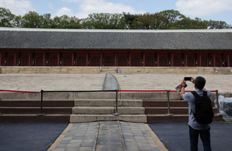 지난 21일 5년간의 수리를 마친 서울 종묘를 방문한 한 관람객이 휴대전화로 정전의 모습을 담고 있다. 연합뉴스