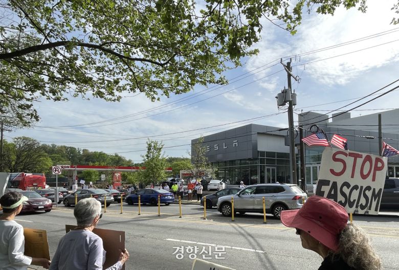 미국 버지니아주 알링턴의 테슬라 매장 앞에서 22일(현지시간) 도널드 트럼프 대통령 반대집회가 열리고 있다. 워싱턴 | 김유진 특파원