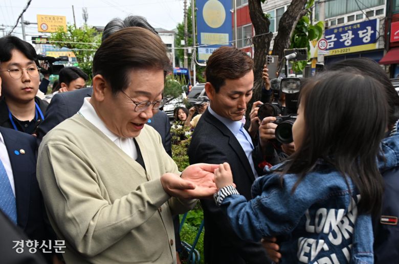 이재명 더불어민주당 대선 후보가 6일 충북 옥천군 옥천공설시장에서 아이에게 손을 내밀고 있다. 성동훈 기자