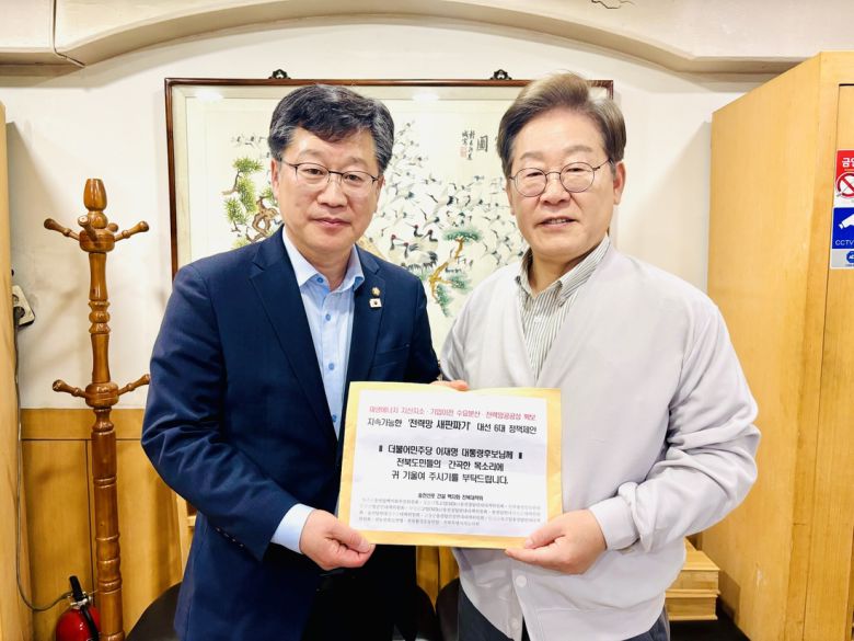 국회 환경노동위원회 위원장인 안호영 의원(왼쪽)이 이재명 더불어민주당 대선 후보에게 ‘전력망 새판짜기’ 대선 6대 정책제안을 전달하고 있다. 전북환경운동연합 제공