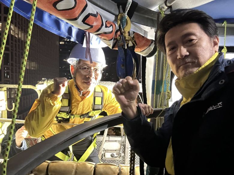 권영국 민주노동당 대선 후보가 제21대 대통령 선거 공식 선거운동 첫날인 12일 서울 장교동 한화그룹 본사 앞에서 고공농성 중인 한화오션조선소 하청노동자 김형수씨를 찾아 함께 사진 촬영을 하고 있다. 김형수씨 페이스북 갈무리