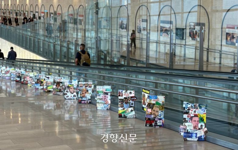 18일(현지시간) 이스라엘 텔아비브 벤구리온 공항에 놓여있는 인질들 사진. 김희진 기자