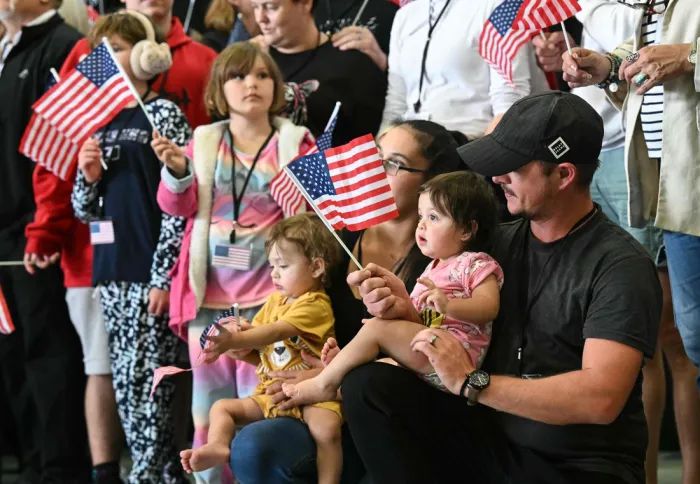 난민 자격으로 미국에 입국한 남아프리카공화국의 백인들이 12일(현지시간) 미국 워싱턴 덜레스 국제 공항에 도착해 미국 국기를 흔들고 있다. AFP연합뉴스